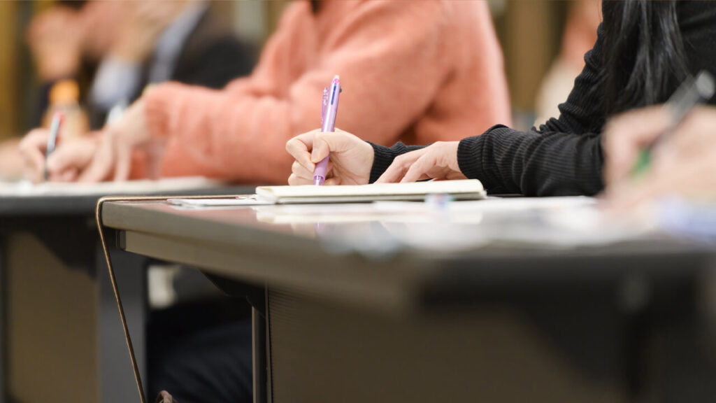 社内勉強会でメモを取る女性